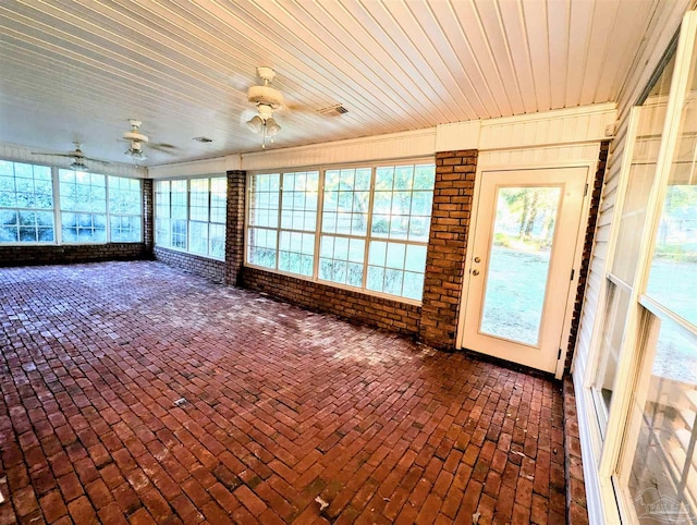 unfurnished sunroom featuring ceiling fan