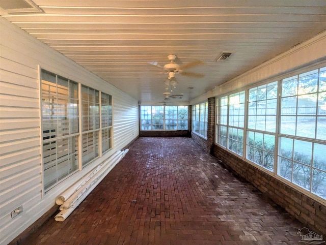 unfurnished sunroom with ceiling fan and plenty of natural light