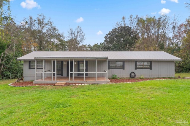 back of house with a sunroom and a yard