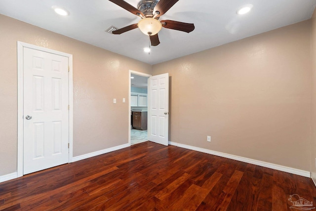 unfurnished bedroom featuring ceiling fan and dark hardwood / wood-style flooring