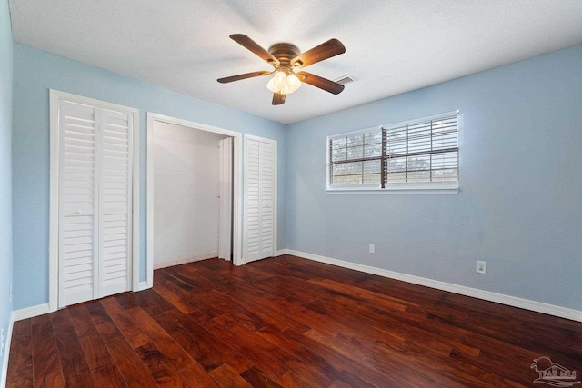 unfurnished bedroom featuring ceiling fan and dark hardwood / wood-style floors