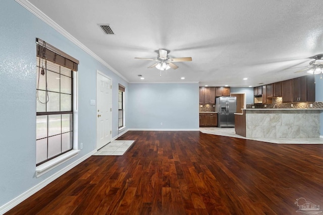 unfurnished living room with ceiling fan, crown molding, dark hardwood / wood-style flooring, and a textured ceiling