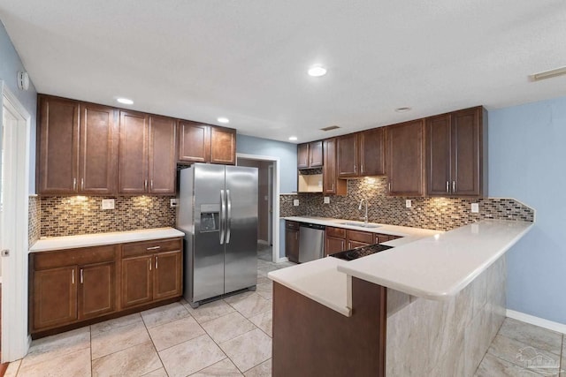 kitchen featuring kitchen peninsula, appliances with stainless steel finishes, sink, light tile patterned floors, and a breakfast bar area