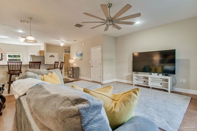 living room with ceiling fan and light wood-type flooring