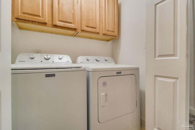 washroom with washer and clothes dryer and cabinets