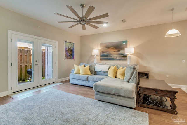 living room with french doors, light hardwood / wood-style floors, and ceiling fan