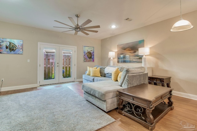 living room featuring french doors, light wood-type flooring, and ceiling fan