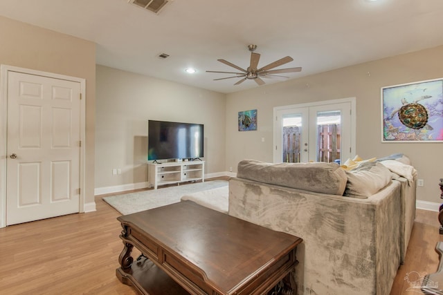 living room featuring ceiling fan, light hardwood / wood-style flooring, and french doors