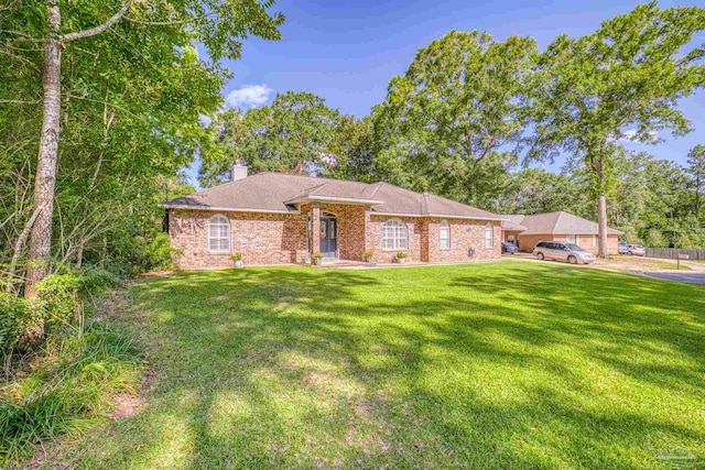 single story home with brick siding, a chimney, and a front yard