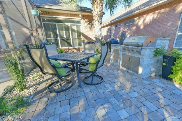 view of patio featuring outdoor dining space, exterior kitchen, and area for grilling