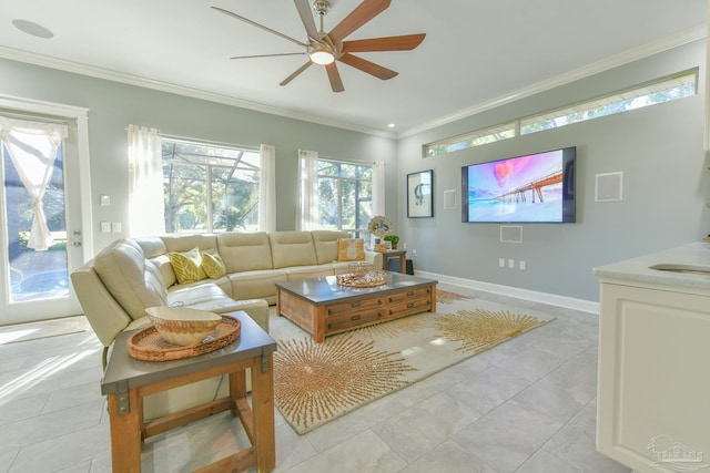 living area with light tile patterned floors, baseboards, ceiling fan, and crown molding