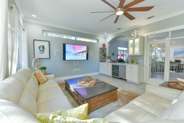 living area with beverage cooler, visible vents, bar, and crown molding
