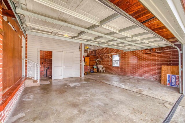 garage with wooden walls and a garage door opener