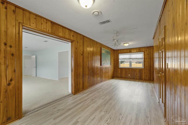 empty room with light hardwood / wood-style flooring and ceiling fan