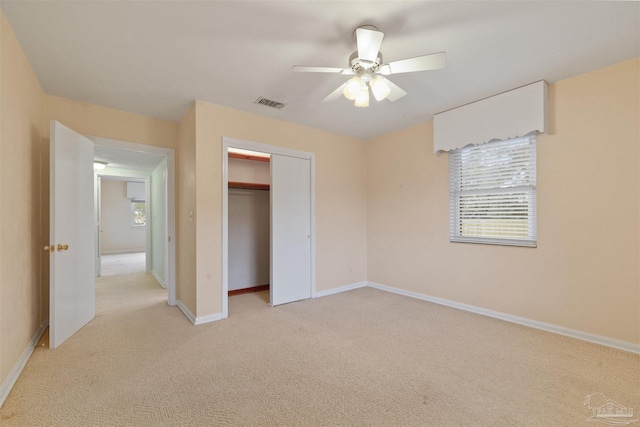 unfurnished bedroom with ceiling fan, light colored carpet, and a closet