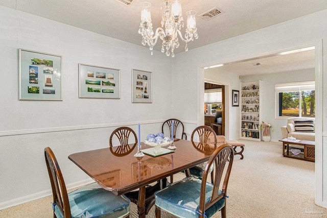 carpeted dining area with an inviting chandelier