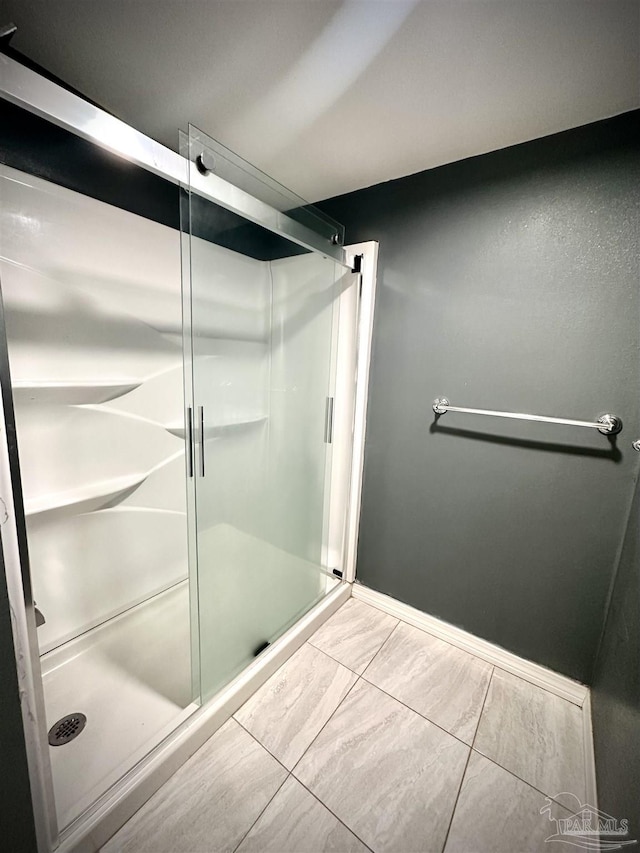 bathroom with tile patterned floors and walk in shower