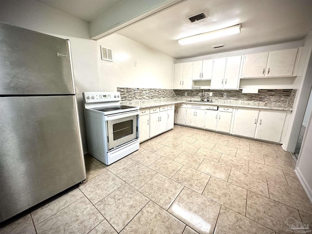 kitchen featuring white electric range oven, white cabinetry, sink, and stainless steel refrigerator