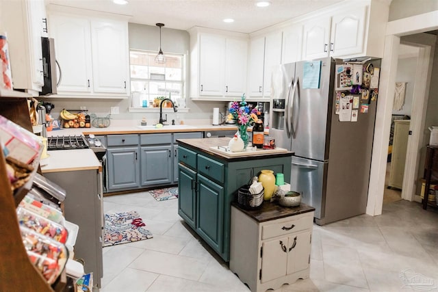 kitchen featuring white cabinetry, appliances with stainless steel finishes, a center island, and sink