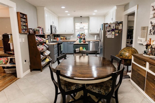 tiled dining area featuring a textured ceiling