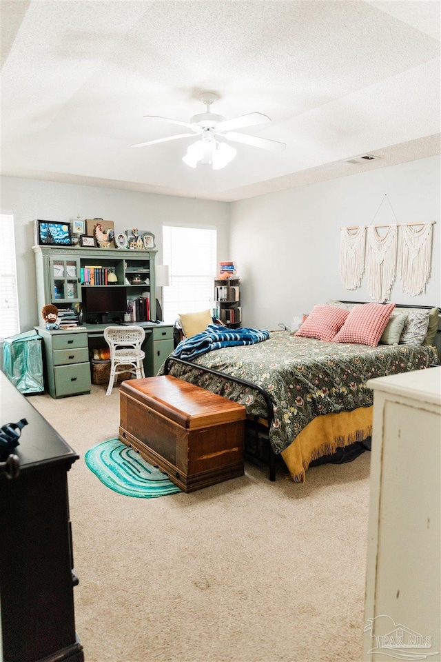 bedroom with a textured ceiling, ceiling fan, and carpet flooring