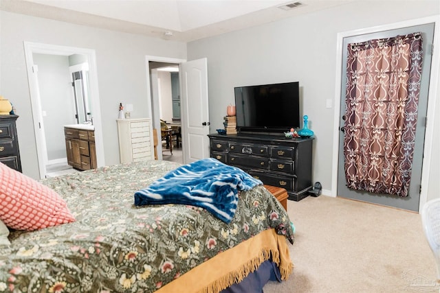 bedroom featuring ensuite bath and light colored carpet