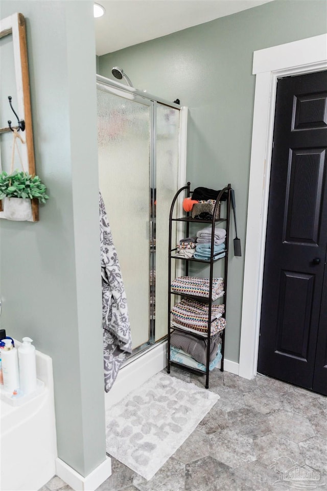 bathroom featuring a shower with door