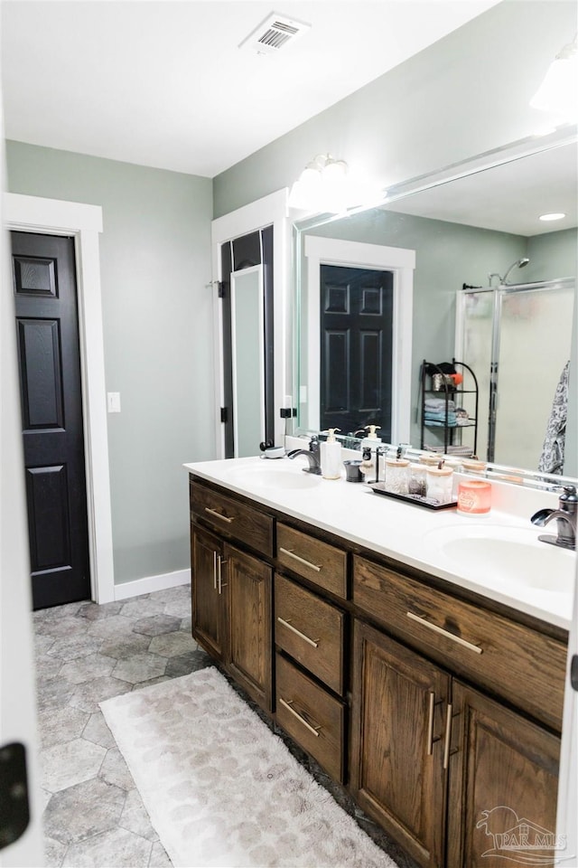 bathroom with vanity and a shower with door