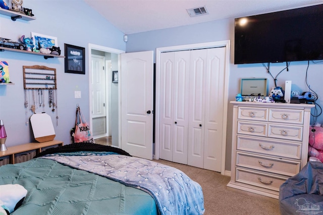 carpeted bedroom featuring vaulted ceiling and a closet