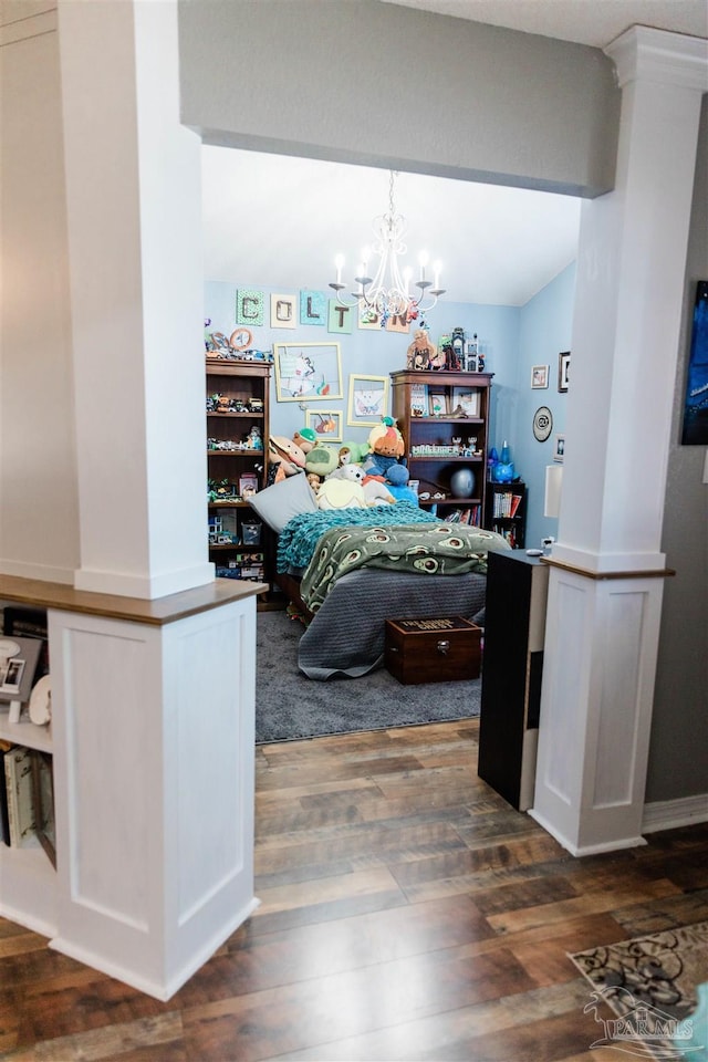 bedroom featuring decorative columns, dark wood-type flooring, and a notable chandelier