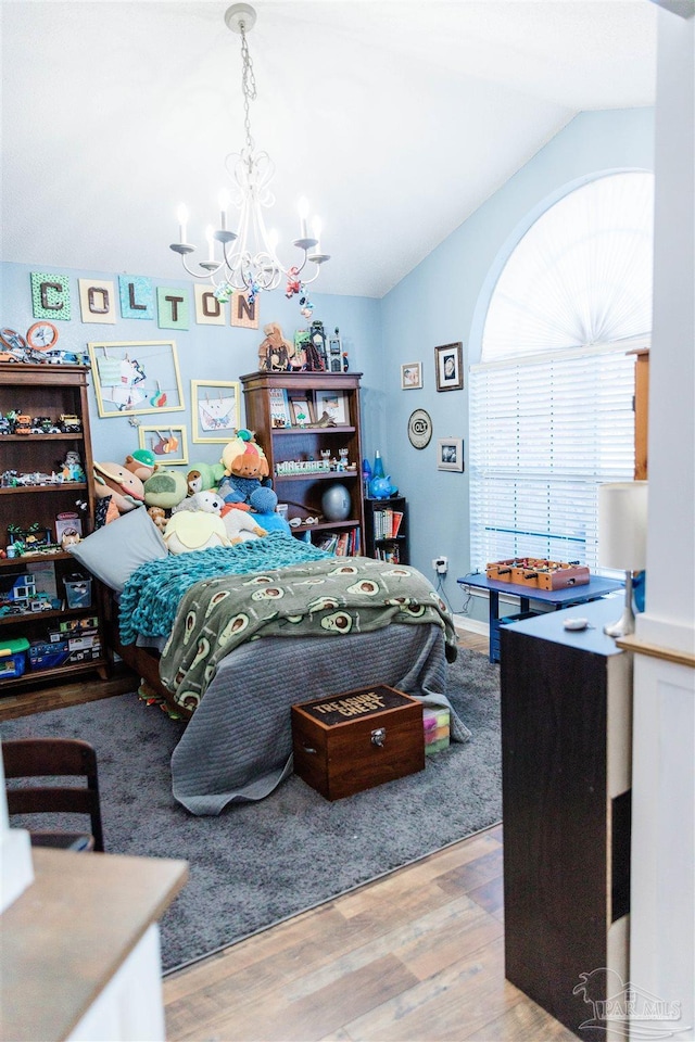 bedroom with lofted ceiling, a chandelier, and light hardwood / wood-style flooring