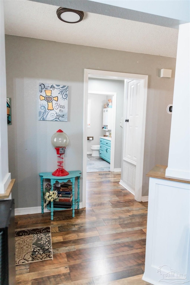 hall featuring dark wood-type flooring and a textured ceiling