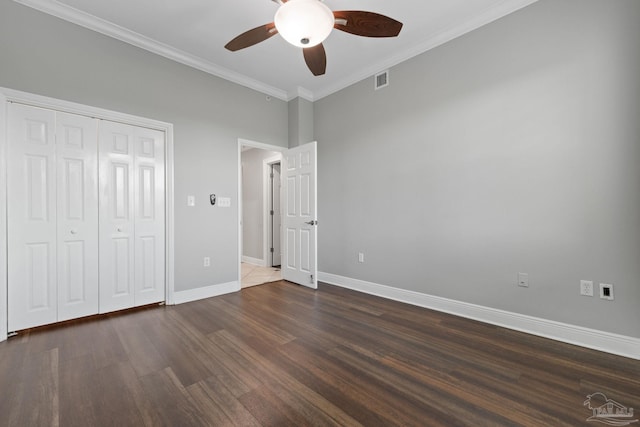 1700 Scenic Hwy Unit 404, Pensacola, FL 32503 - unfurnished bedroom with dark wood-style flooring, baseboards, crown molding, ceiling fan, and a closet
