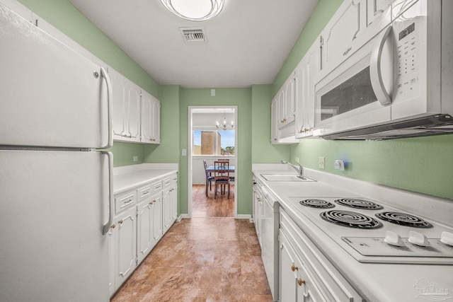 kitchen with white appliances, a sink, visible vents, white cabinets, and light countertops