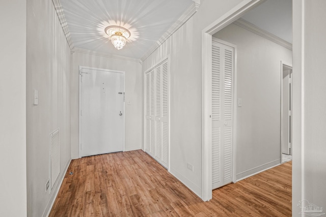 hall with visible vents, crown molding, and wood finished floors