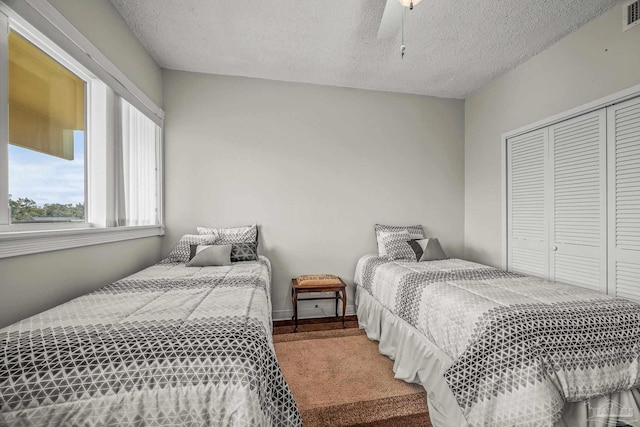 bedroom with a closet, visible vents, a textured ceiling, and baseboards