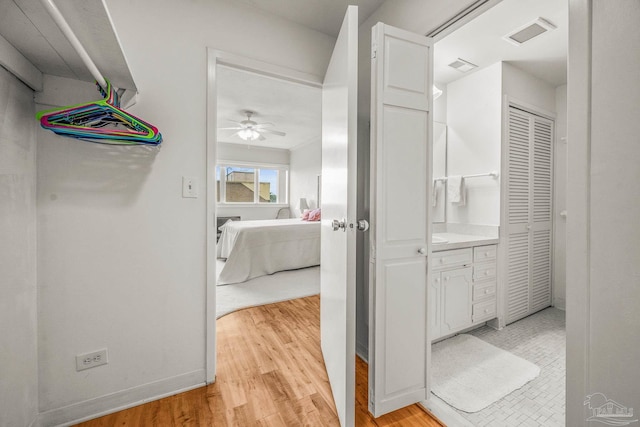 bathroom featuring a ceiling fan, wood finished floors, visible vents, and baseboards