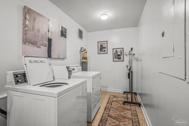 washroom with light tile patterned floors, baseboards, visible vents, and independent washer and dryer