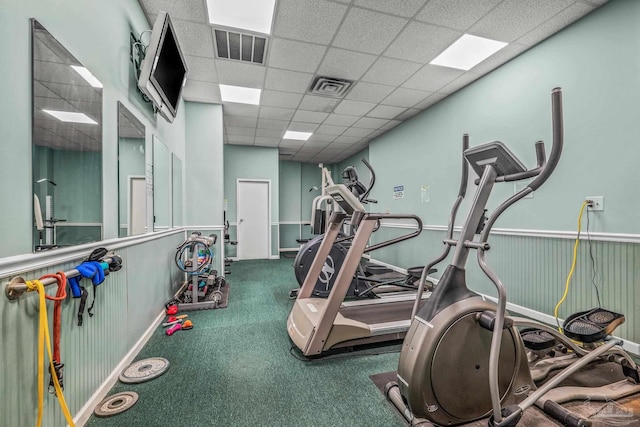 exercise area featuring wainscoting, a drop ceiling, and visible vents