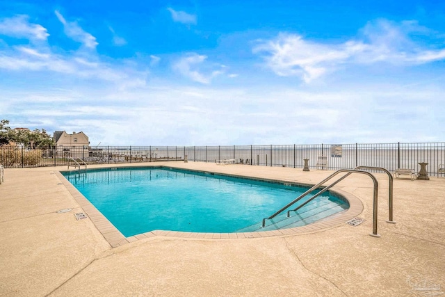 community pool featuring fence and a patio