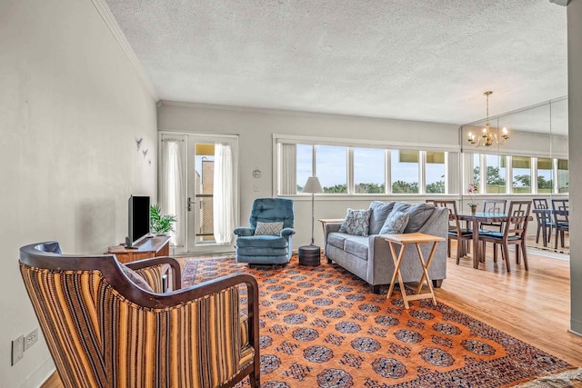 living room with a notable chandelier, crown molding, a wealth of natural light, and wood finished floors