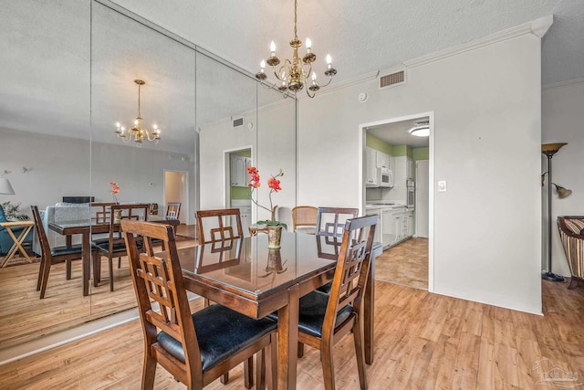 dining area featuring light wood-type flooring, visible vents, and a chandelier