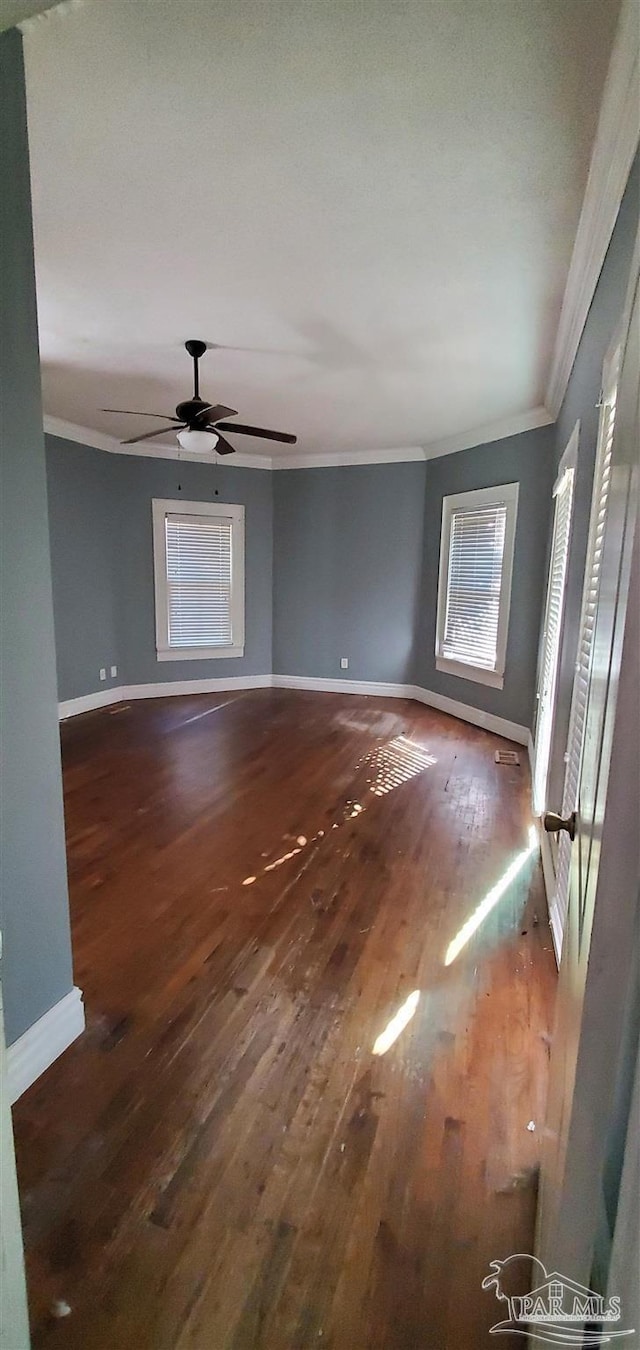 unfurnished room featuring ceiling fan, crown molding, and dark hardwood / wood-style floors