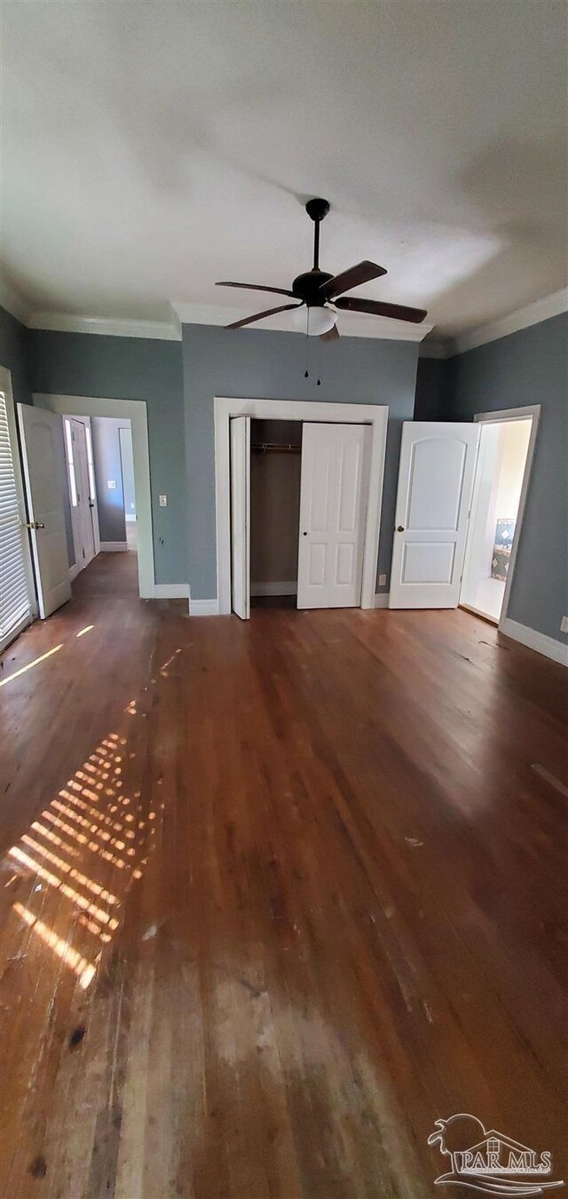 unfurnished living room featuring ceiling fan, ornamental molding, and dark hardwood / wood-style floors