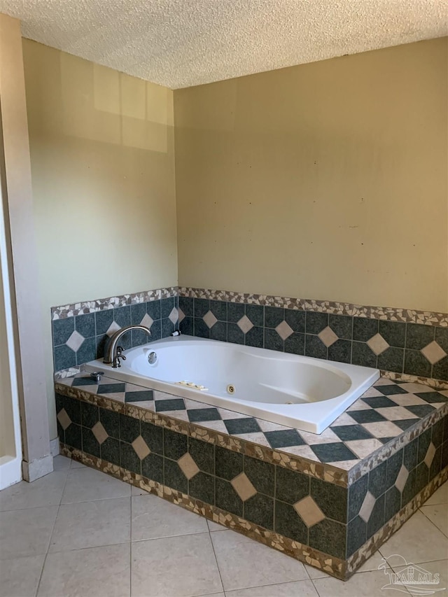 bathroom featuring tile patterned floors, a textured ceiling, and tiled bath