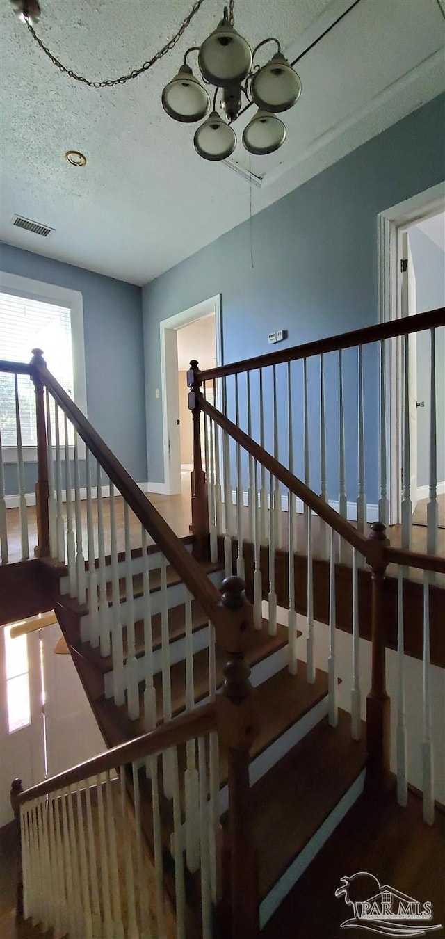 staircase featuring wood-type flooring and a textured ceiling