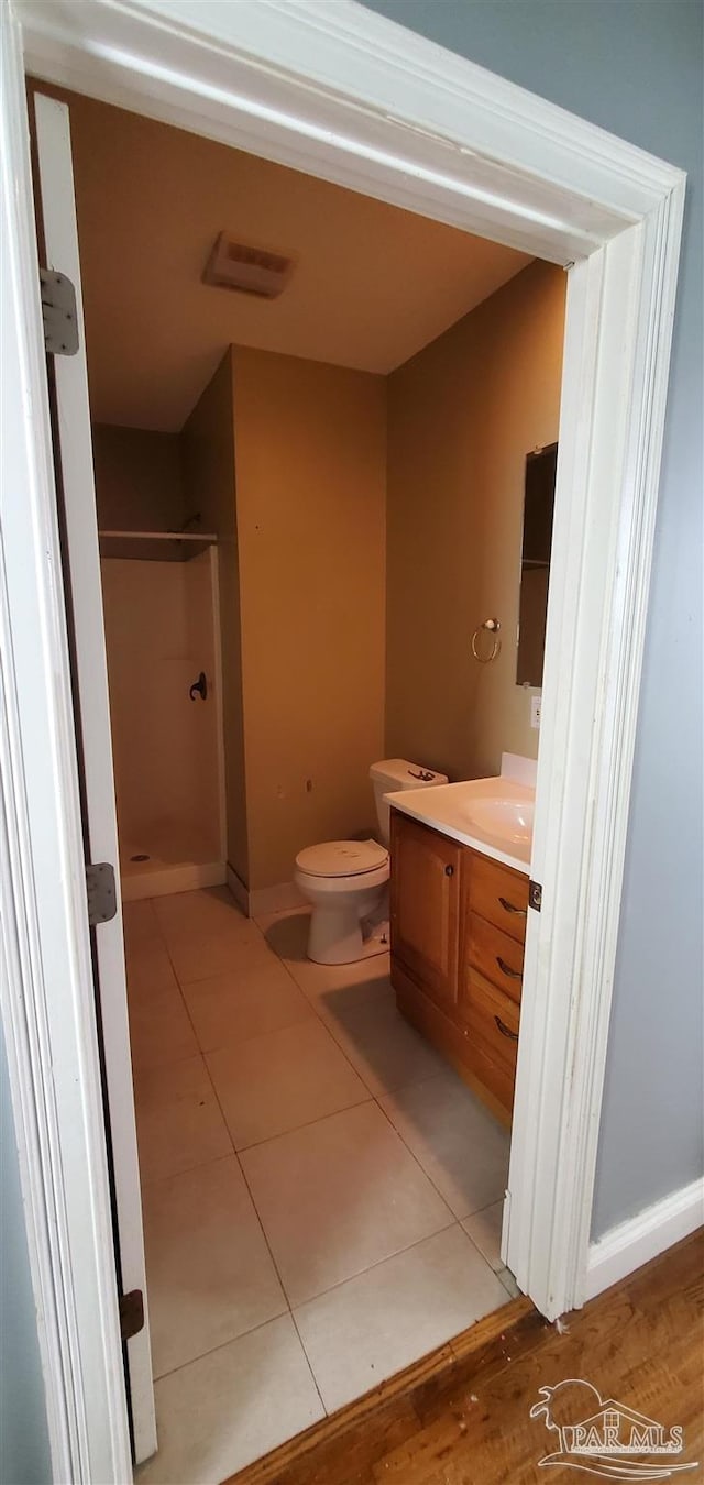 bathroom with vanity, tile patterned floors, a shower, and toilet