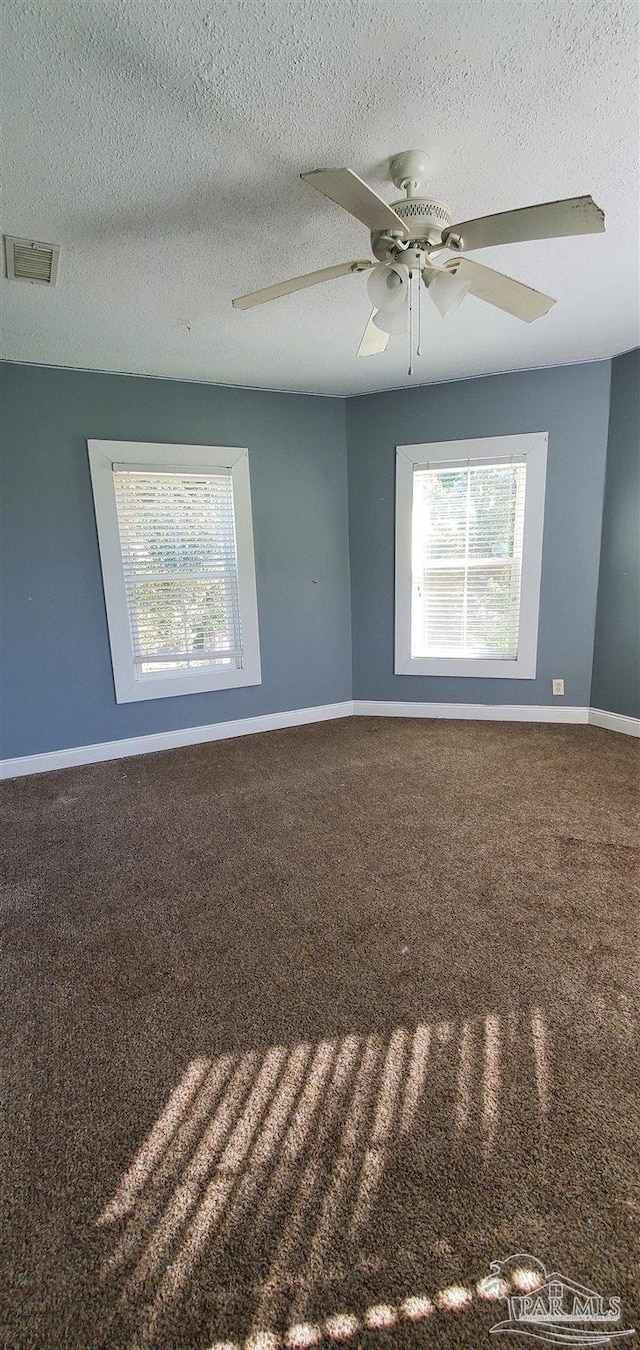 spare room with a textured ceiling, ceiling fan, and plenty of natural light