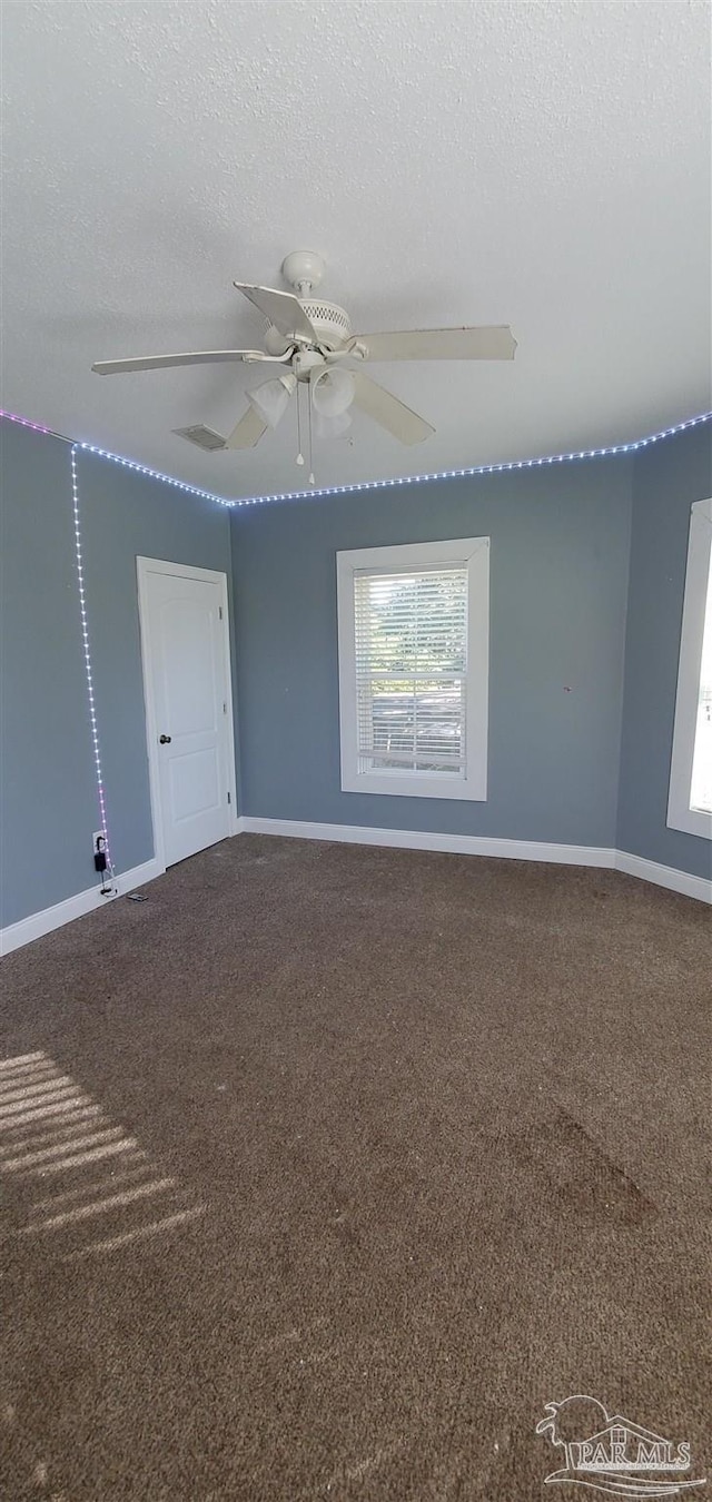 empty room featuring a textured ceiling, carpet floors, and ceiling fan