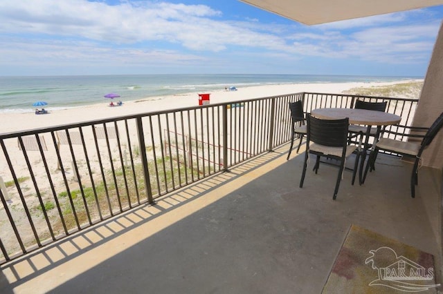 balcony with a water view and a view of the beach